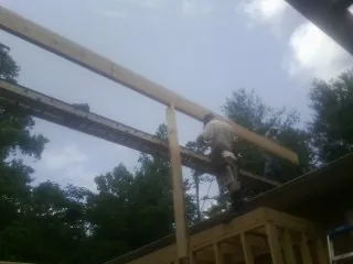 Carpenter setting a ridge beam over a new addition frame — Ice Dam Removal by Roofing Brothers in Latah