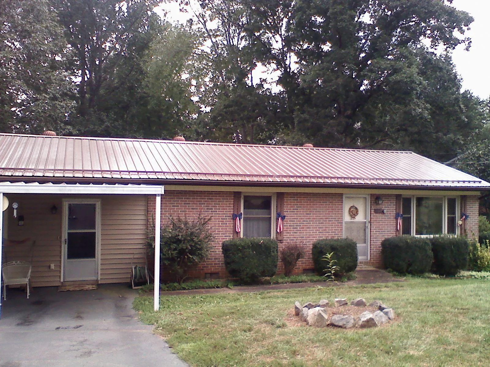 Bronze metal roof and carport on a brick ranch home — Roof Repair work by our crew in Latah